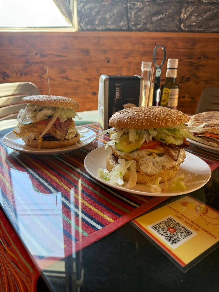 Two house burgers served on a terrace table